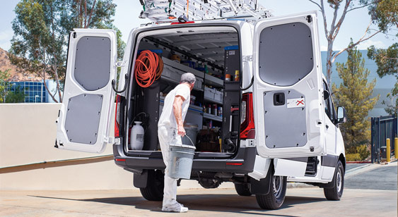 Worker leaning into back of 2022 Sprinter Van with open doors